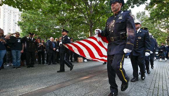 Los miembros de la policía de Nueva York llevan una bandera estadounidense durante una ceremonia en la Zona Cero en el vigésimo aniversario de los ataques del 11 de septiembre en Manhattan. (Foto:  Anthony Behar / POOL / AFP)