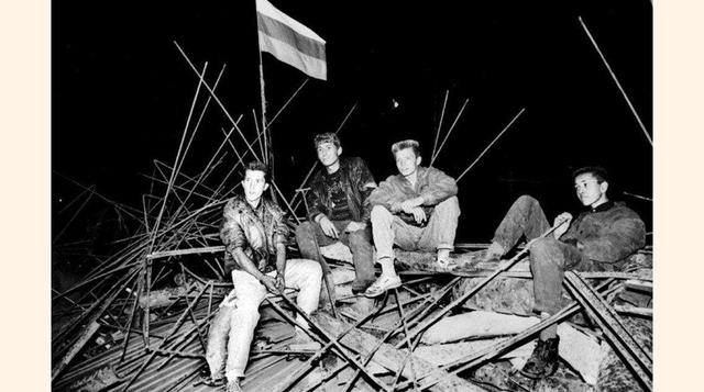 Unos jóvenes se sientan bajo una bandera rusa en una barricada ante la Casa Blanca Rusa, en el corazón de Moscú, el 20 de agosto de 1991 de madrugada.(foto:Alexander Nemenov).
