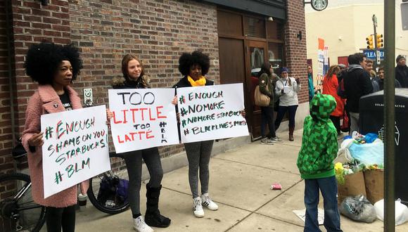 Protestas afuera de un Starbucks después de que dos hombres negros fueran arrestados por esperar en el local sin ordenar nada. (Foto: AP)
