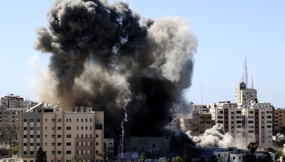 Una espesa columna de humo se eleva desde una torre cuando es destruida en un ataque aéreo israelí en la ciudad de Gaza controlada por el movimiento palestino Hamas, el 15 de mayo de 2021.  (MAHMUD HAMS / AFP).