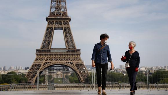 Imagen referencial. Las personas que usan una mascarilla por el coronavirus caminan cerca de la Torre Eiffel en París (Francia), el 20 de abril de 2020. (THOMAS COEX / AFP).