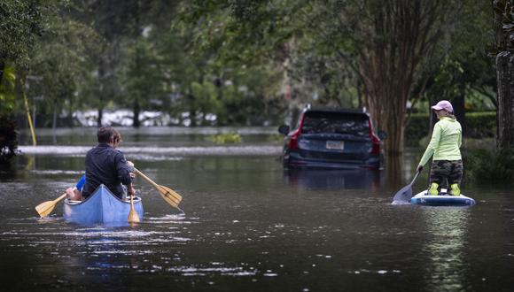 La gente navega en canoa y rema en una calle inundada después del huracán Ian en Orlando, Florida, el 29 de septiembre de 2022. (Foto de Jim WATSON / AFP)