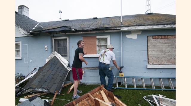 Habitantes del condado de Lupton, Michigan (EE.UU.), revisan el estado en que quedó su vivienda luego del paso de una tormenta que dañó casas y arrancó árboles. (Foto: AP)