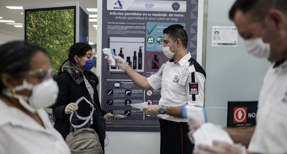 México. Personal revisa la temperatura de los pasajeros como medida preventiva durante la pandemia del coronavirus, en el aeropuerto internacional Benito Juárez de la Ciudad de México, el 20 de mayo de 2020. (PEDRO PARDO / AFP).