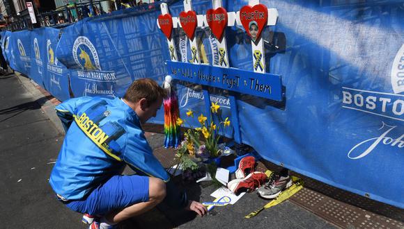 Un hombre coloca un recuerdo el 20 de abril de 2014 en un monumento improvisado instalado en el lugar donde estalló la bomba cerca de la línea de meta del maratón de Boston de 2013 en Boston, Massachussetts (Foto: Timothy A. Clary / AFP )