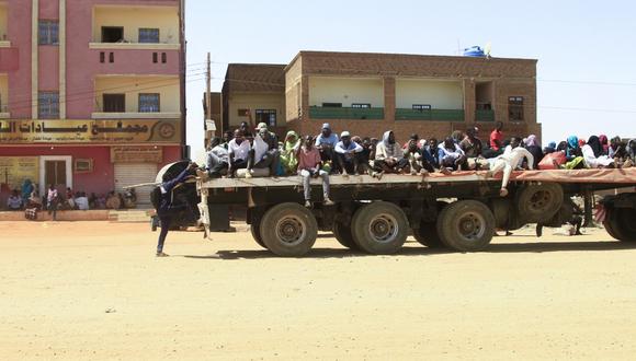 Personas huyen de las batallas callejeras entre las fuerzas armadas de dos generales sudaneses rivales. Son transportadas en la parte trasera de un camión en la parte sur de Jartum, el 21 de abril de 2023. (Photo by AFP)