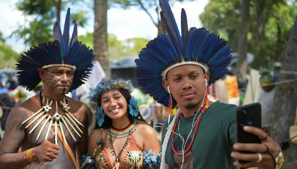 Activista digital Samela Awiá, de la tribu Satere Mawé Amazonian (en el centro) y Tukumã Pataxó de la tribu Patio (a la izq) se toman un selfie con un fan. Carl de Souza/AFP PHOTO