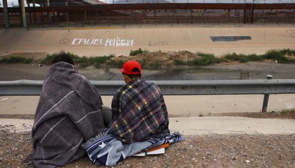 Migrantes venezolanos descansan a orillas del río Bravo luego de ser expulsados de Estados Unidos, en Ciudad Juárez, estado de Chihuahua, México, el 17 de octubre de 2022. (Foto de HERIKA MARTINEZ / AFP)
