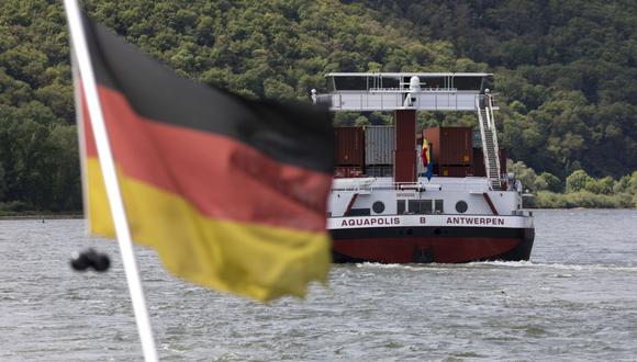 Una bandera nacional alemana ondea desde el petrolero 'Erik Walther' mientras el carguero 'Aquapolis' transporta contenedores en el río Rin, cerca de Bingen, Alemania, el jueves 16 de mayo de 2019. Fotógrafo: Alex Kraus/Bloomberg