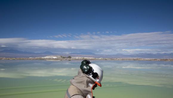 Un visitante pasa frente a un lago de salmuera en una mina de litio de la Sociedad Química y Minera de Chile (SQM) en el salar de Atacama en el desierto de Atacama, Chile, el miércoles 29 de mayo de 2019. Photographer: Cristobal Olivares/Bloomberg