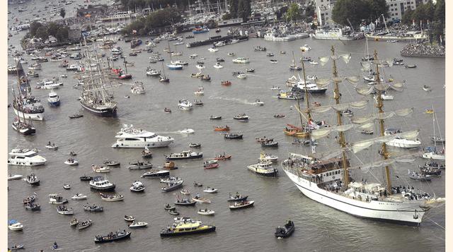 El velero polaco Dar Młodzieży es escoltado por naves menores al iniciar el desfile que marcó el comienzo del SAIL Ámsterdam, la exhibición de naves históricas más importantes del mundo. (Foto: REUTERS)
