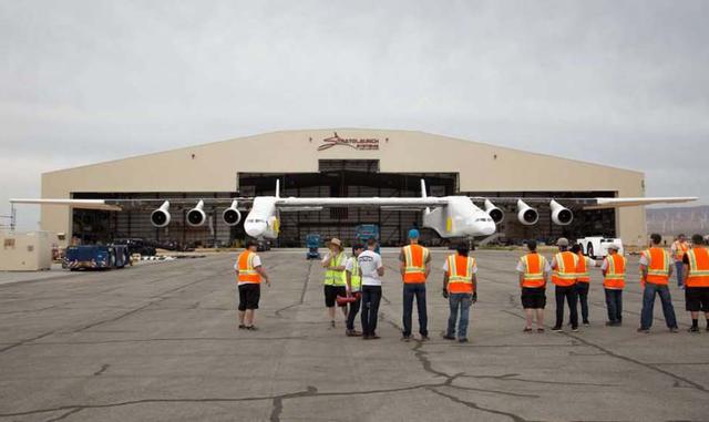 Los miembros del proyecto miran al avión mientras sale del hangar por primera vez en el desierto de Mojave, California.