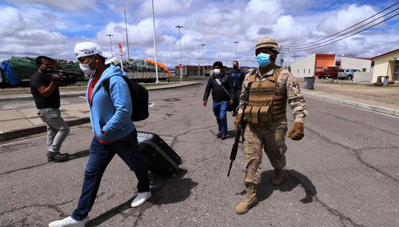 Un soldado chileno escolta a migrantes a las instalaciones policiales en Colchane, Chile, en la frontera con Bolivia, el 15 de febrero de 2022. (Foto: AFP)