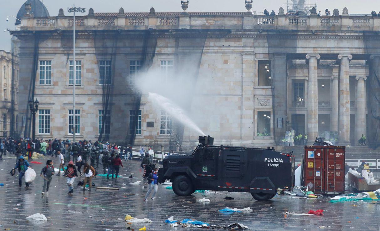 Una tanqueta de la Policía antidisturbios dispersa a un grupo de manifestantes en la Plaza de Bolívar el jueves, durante el desarrollo del denominado Paro Nacional, en Bogotá (Colombia). Estudiantes y trabajadores colombianos tomaron este jueves las calles del país para protestar contra la política económica y social del presidente Iván Duque en una jornada que prácticamente paralizó el comercio y el tráfico en las avenidas. EFE/Mauricio Dueñas Castañeda