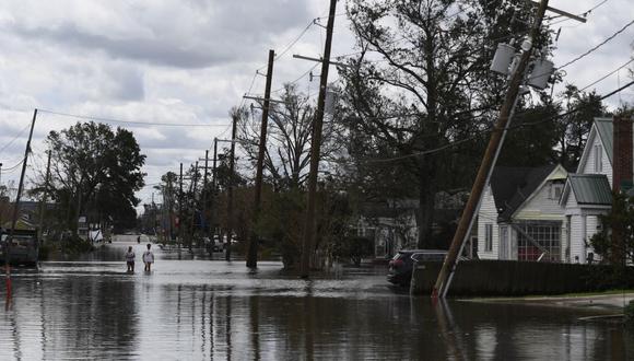 La gente camina a través de las inundaciones provocadas por el huracán Ida en Norco, Louisiana, el 30 de agosto de 2021. (PATRICK T. FALLON / AFP).