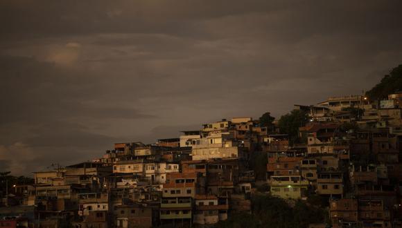 Vista de casas en la cima de una montaña en la ciudad de Niteroi durante el amanecer visto desde el puente Río-Niteroi en el estado de Río de Janeiro, Brasil, el 7 de febrero de 2022. (Foto de MAURO PIMENTEL / AFP)
