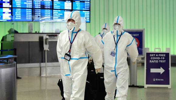 La tripulación de vuelo de Air China llegó con trajes de materiales peligrosos a la terminal internacional del Aeropuerto Internacional de Los Ángeles el 3 de diciembre de 2021, cuando el condado de Los Ángeles informó su primer caso de la nueva variante Covid-19, ómicron. (Foto de Frederic J. BROWN / AFP)