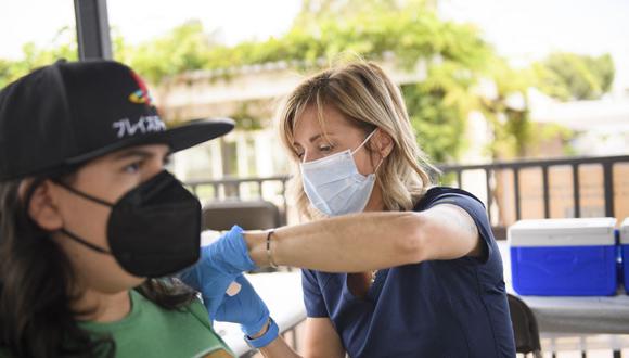 Una enfermera administra una dosis de la vacuna Pfizer Covid-19 a una estudiante de secundaria en Long Beach, Estados Unidos. (Foto de Patrick T.FALLON / AFP).