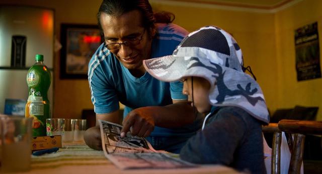 FOTO 1 | Callizaya y su hijo leen cómics en su casa. (Foto: Reuters/  Manuel Seoane)