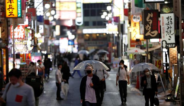 Las personas que usan máscaras de protección por el coronavirus (COVID-19) caminan por el distrito de Kabukicho en Tokio, Japón. (REUTERS/Issei Kato).