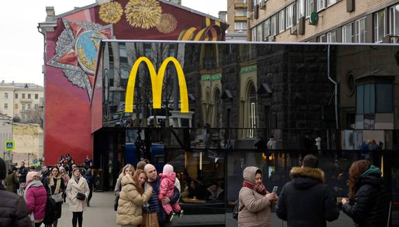 En esta foto de archivo tomada el 13 de marzo de 2022, la gente se toma fotos frente al restaurante insignia de McDonald's en la plaza Pushkinskaya, el primero de la cadena que abrió en Rusia el 31 de enero de 1990. (AFP).