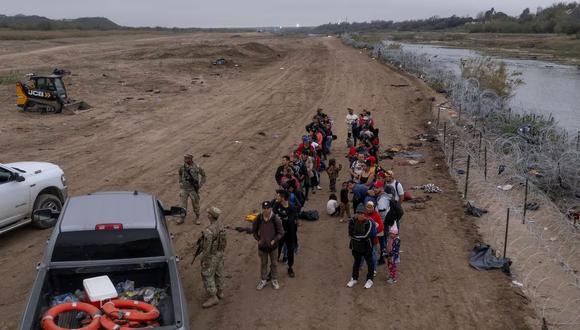 Migrantes esperan para ser procesados, luego de cruzar el río Bravo, en Eagle Pass (Texas).
CHENEY ORR (REUTERS)