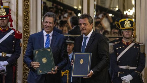 El ministro de Hacienda de Brasil, Fernando Haddad, a la izquierda, y el ministro de Economía de Argentina, Sergio Massa, sostienen documentos firmados durante una conferencia de prensa en la Casa Rosada de Buenos Aires el 23 de enero. (Foto: Bloomberg)