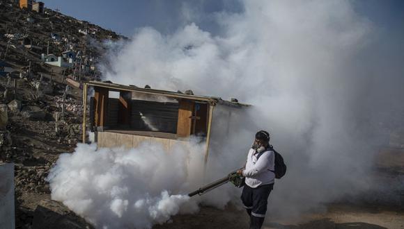 Un especialista fumiga el cementerio de Nueva Esperanza contra el mosquito Aedes que transmite el dengue, así como el chikungunya y el zika, en las afueras de Lima el 1 de junio de 2022. (Foto de Ernesto Benavides / AFP)