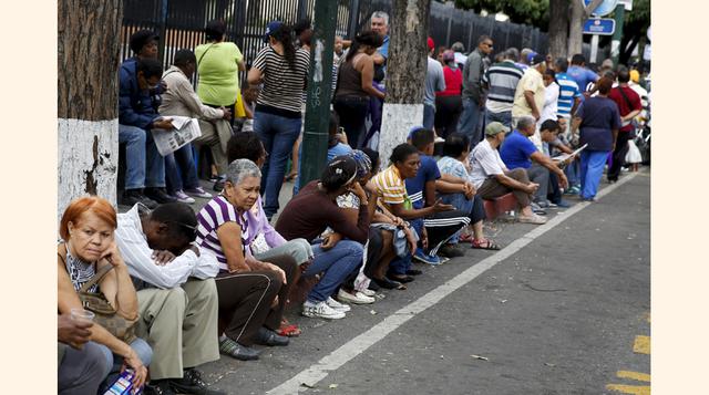 Los venezolanos hacen cola para comprar artículos de primera necesidad fuera del supermercado Bicentenario en la capital de su país. A pesar de ello y de atravesar una recesión económica con la inflación más alta de América, pocos creen que se vuelvan a r