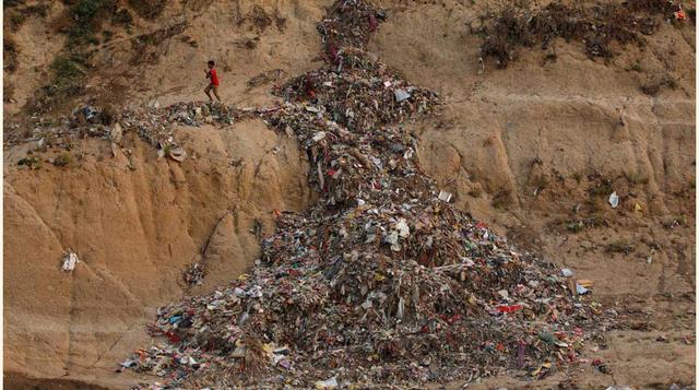 Un niño atraviesa una montaña de basura a las orillas del Ganges en Mirzapur.