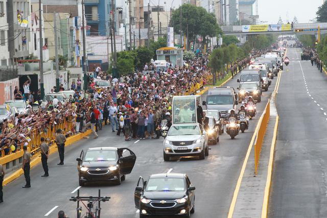 Foto 2 | Horas antes de que el vuelo que transporta al líder de la iglesia Católica aterrice en la capital peruana procedente de Chile, ya eran centenares las personas que esperaban a pie de calle en el recorrido que hará la comitiva papal desde el aeropuerto hasta la Nunciatura Apostólica, donde hoy descansará Francisco.