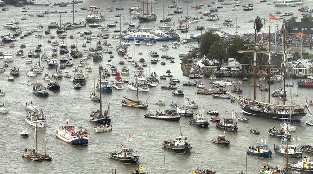 Ingreso al puerto de Ámsterdam de decenas de embarcaciones que participarán en la novena edición del SAIL Ámsterdam 2015, festival que hasta este domingo 23 presentará a las más importantes y valiosas naves históricas y réplicas de barcos antiguos del mun
