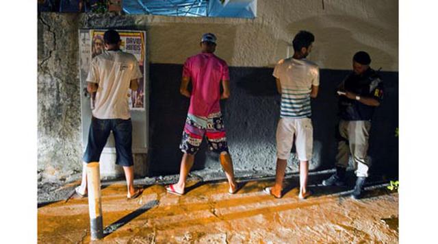 Maceio, Brasil. Homicidios: 733. Población: 1.005.319. Tasa de homicidios: 72.91. Miembros de la policía militarizada indagan a un sospechoso aprehendido por posesión de marihuana, durante un operativo en la favela Virgem dos Pobres en Maceio.
