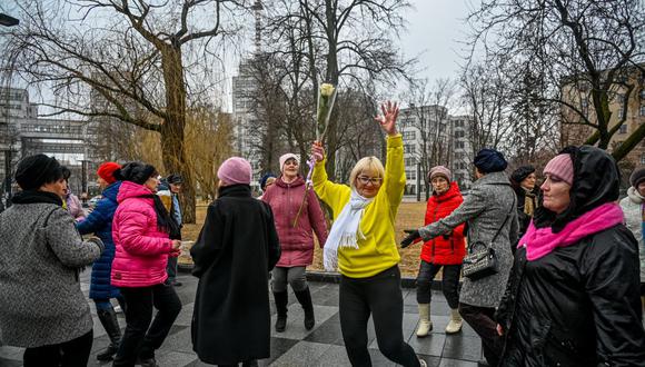 Las mujeres bailan para conmemorar el Día Internacional de la Mujer en Freedom Square en Kharkiv el 8 de marzo de 2023, en medio de la invasión rusa de Ucrania. (Foto de SERGEY BOBOK / AFP)