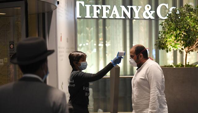 Un guardia de seguridad toma la temperatura de un comprador en el Dubai Mall de Emiratos Árabes Unidos. (Karim SAHIB / AFP).