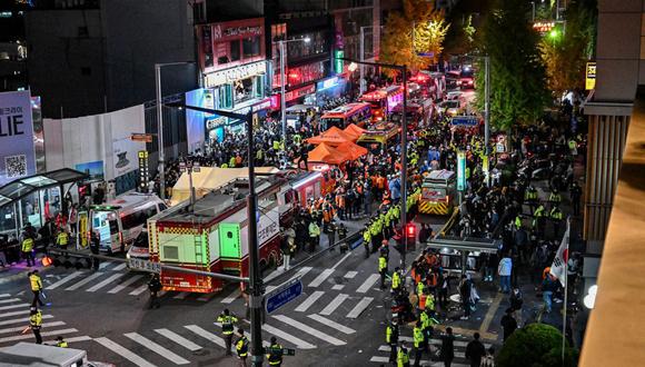 Los espectadores, la policía y los paramédicos se reúnen donde decenas de personas sufrieron un paro cardíaco, en el popular distrito de vida nocturna de Itaewon en Seúl el 30 de octubre de 2022. (Foto de JUNG YEON-JE / AFP)