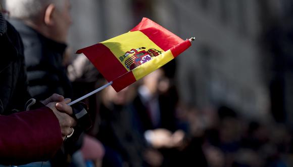 Una mujer sostiene una bandera española fuera del edificio del parlamento durante los actos que marcan el 40 aniversario de la Constitución española en el parlamento de Madrid el 6 de diciembre de 2018. (Foto de CURTO DE LA TORRE / AFP)