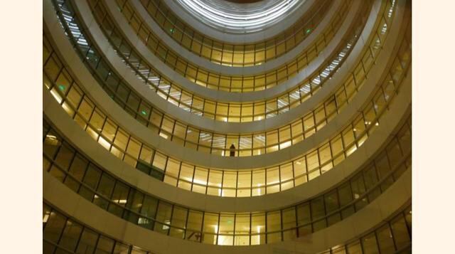 Un empleado está parado fuera de la oficina de una compañía de ventas en línea durante la noche en Galaxy Soho, en Pekín, China. (Foto: Reuters)