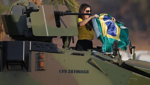 Un manifestante muestra una bandera nacional brasileña en el vehículo blindado del ejército para apoyar los ataques del presidente de Brasil, Jair Bolsonaro, contra la Corte Suprema del país, en Brasilia, Brasil, el 7 de setiembre de 2021. (REUTERS / Adriano Machado).
