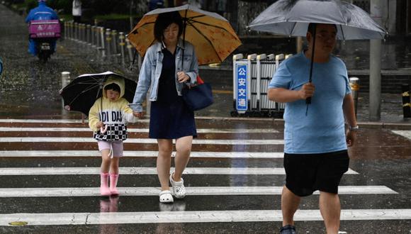 Las personas se refugian de la lluvia con paraguas en Pekín, el 30 de julio de 2023. China decretó la alerta roja en varias zonas del norte del país, incluida la región de Pekín, debido a las lluvias torrenciales que ha dejado el avance del tifón Doksuri (Foto:AFP)