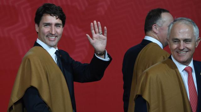 El primer ministro de Canadá, Justin Trudeau, levanta la mano en señal de saludo, mientras sonríe el primer ministro de Australia, Malcolm Turnbull. (Foto: AFP)