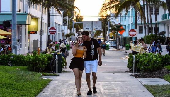 Joven pareja camina por Ocean Drive en Miami Beach, Florida en junio del 2020. AFP / CHANDAN KHANNA
