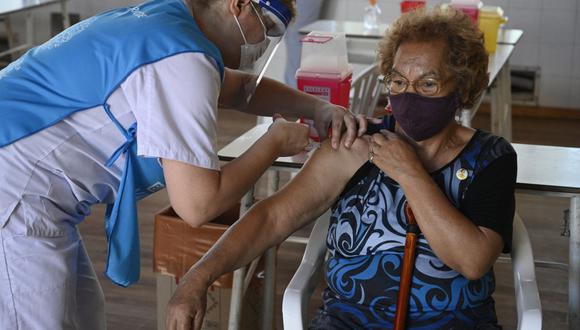 Un trabajador de salud aplica una dosis de la vacuna Sputnik V contra COVID-19 a un anciana en Ezeiza, a las afueras de Buenos Aires (Argentina). (JUAN MABROMATA / AFP).