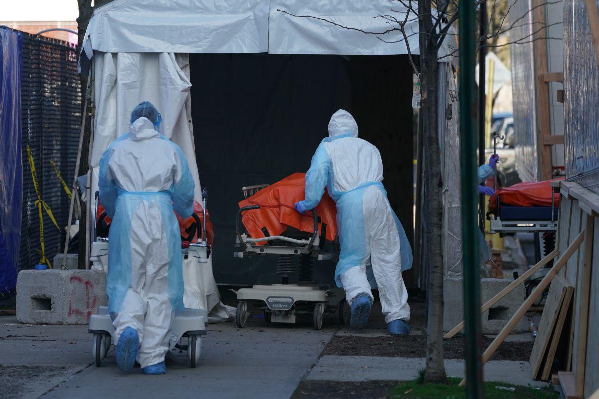 Bodies are moved to a refrigerator truck serving as a temporary morgue outside of Wyckoff Hospital in the Borough of Brooklyn on April 4, 2020 in New York. - New York state's coronavirus toll rose at a devastating pace to 3,565 deaths Saturday, the governor said, up from 2,935 the previous day, the largest 24-hour jump recorded there. (Photo by Bryan R. Smith / AFP)