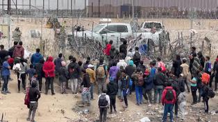 Migrantes intentan derribar alambre de púas en frontera México-Estados Unidos