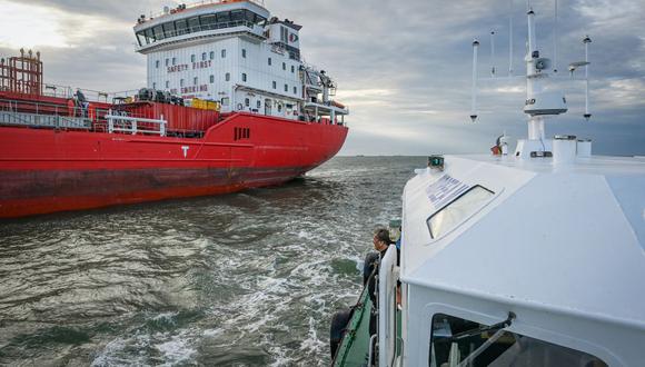 El personal de navegación rumano en un buque piloto supervisa un barco previamente anclado en el Mar Negro que ahora se prepara para ingresar al canal de Sulina. (Foto de Daniel Mihailescu / AFP)