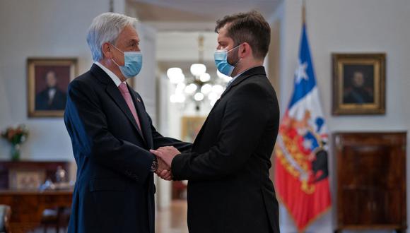 El presidente electo de Chile, Gabriel Boric (derecha), estrecha la mano del mandatario Sebastián Piñera, durante una reunión en el palacio presidencial de La Moneda, el 20 de diciembre de 2021. (Foto: AFP).