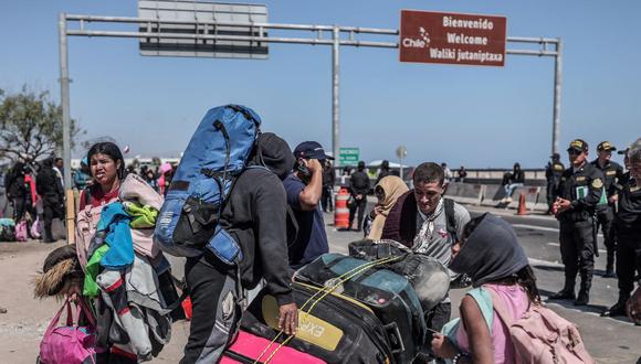 Migrantes de diversas nacionalidades son escoltados por policías peruanos a una oficina de migración en Tacna, en la frontera entre Perú y Chile, el 28 de abril de 2023. (Foto de ALDAIR MEJIA / AFP)