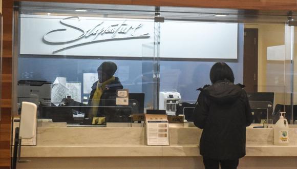 Un trabajador atiende a un cliente en una sucursal de Signature Bank en Nueva York.