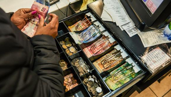 Un trabajador cuenta billetes de rand sudafricanos para cambiarlos en la caja registradora dentro de un supermercado Spar Group Ltd. en el suburbio Die Wilgers de Pretoria, Sudáfrica, el jueves 14 de julio de 2022. (Fotógrafo: Waldo Swiegers/Bloomberg)